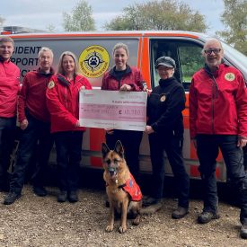 Photo of team members from HSAR Dogs receiving a large cheque from the National Lottery Community Fund